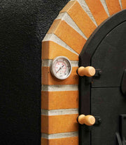 Close-up van een analoge thermometer ingebouwd in een stenen boog van een steenoven